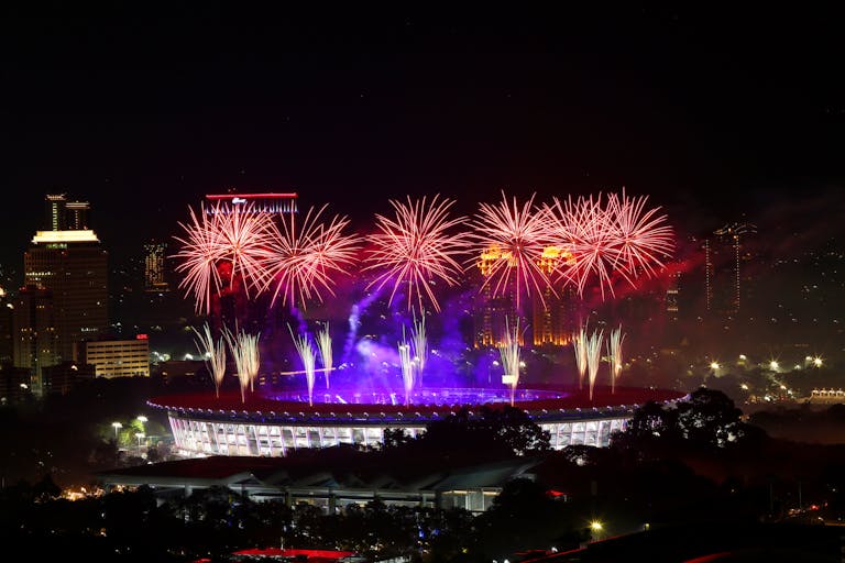Dazzling fireworks display over a stadium, captured during the asian games night.