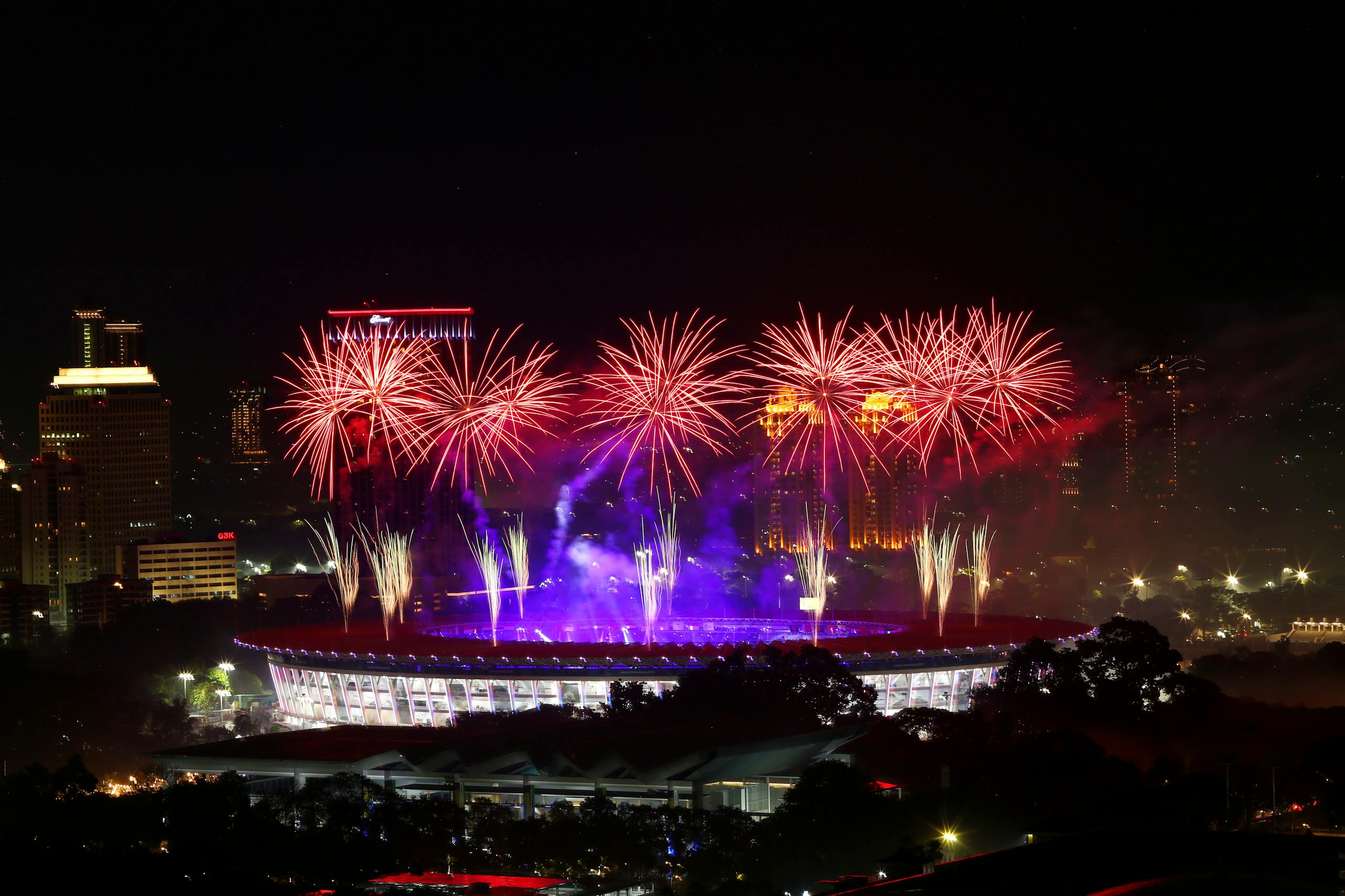 Dazzling fireworks display over a stadium, captured during the asian games night.